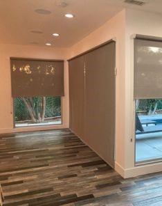 Contemporary Long Beach living room showing large sliding doors with sheer window shades fully raised, allowing maximum daylight.
